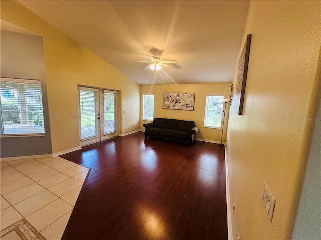 unfurnished living room featuring a healthy amount of sunlight, ceiling fan, light hardwood / wood-style floors, and lofted ceiling