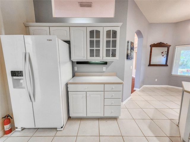 8 Burning Sands Ln, Palm Coast, FL 32137 - kitchen featuring white fridge with ice dispenser, arched walkways, white cabinets, light countertops, and glass insert cabinets