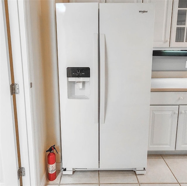 8 Burning Sands Ln, Palm Coast, FL 32137 - kitchen view of white refrigerator with ice dispenser, a fire extinguisher, white cabinetry, and glass insert cabinets