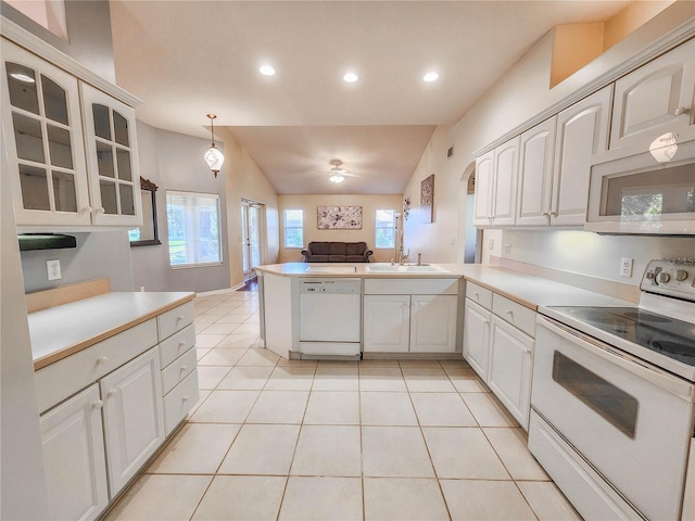 kitchen with kitchen peninsula, lofted ceiling, decorative light fixtures, and white appliances