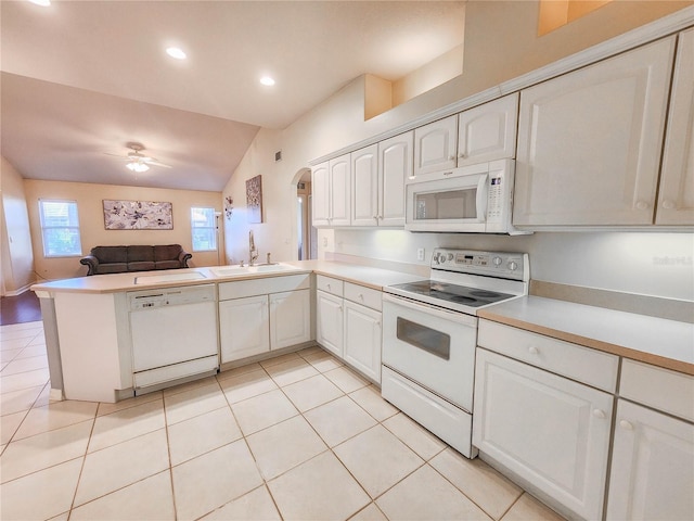 kitchen featuring white cabinetry, sink, kitchen peninsula, vaulted ceiling, and white appliances