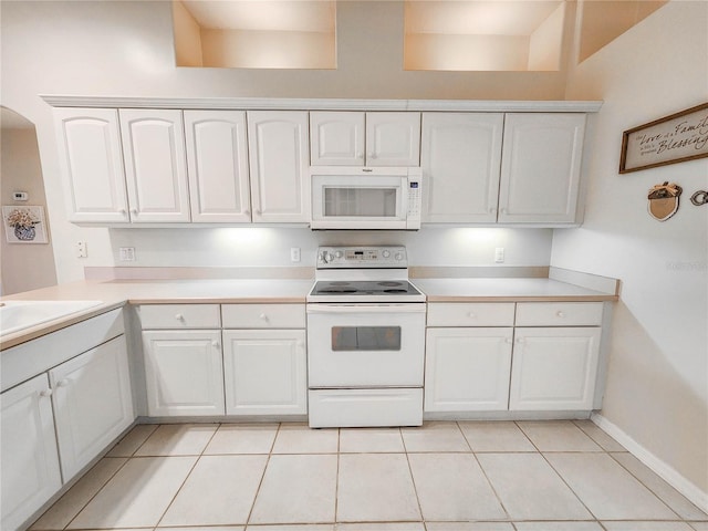 kitchen featuring white cabinets, light tile patterned floors, white appliances, and sink