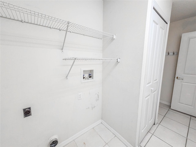 clothes washing area featuring electric dryer hookup, hookup for a washing machine, and light tile patterned floors