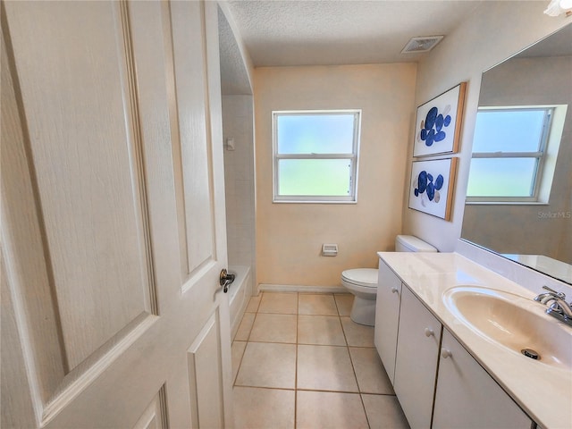 bathroom featuring tile patterned flooring, vanity, a textured ceiling, and toilet