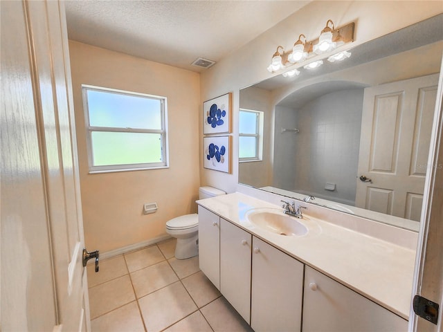 bathroom featuring tile patterned floors, vanity, a textured ceiling, and toilet