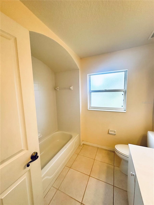 bathroom featuring tile patterned flooring, vanity, a textured ceiling, and toilet