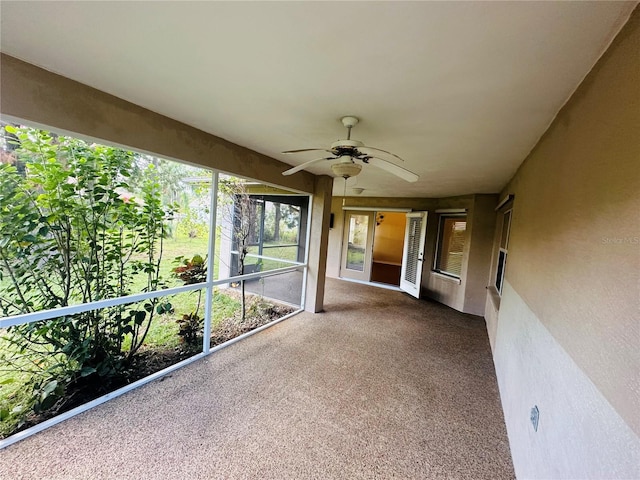 unfurnished sunroom with ceiling fan