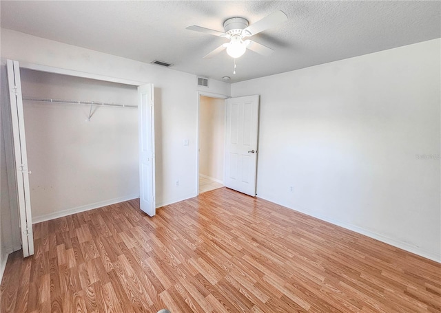 8 Burning Sands Ln, Palm Coast, FL 32137 - unfurnished bedroom with light wood-style flooring, a closet, ceiling fan, and a textured ceiling