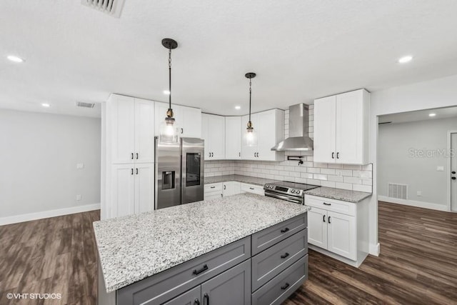 kitchen with gray cabinetry, white cabinets, wall chimney range hood, dark hardwood / wood-style floors, and appliances with stainless steel finishes