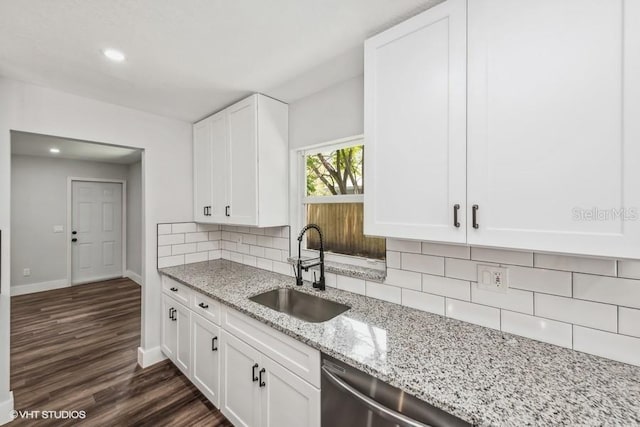 kitchen featuring sink, tasteful backsplash, light stone counters, dark hardwood / wood-style flooring, and white cabinets