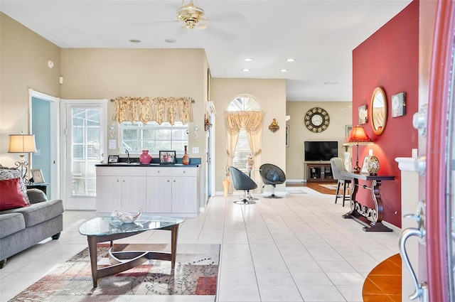 tiled living room featuring ceiling fan and sink