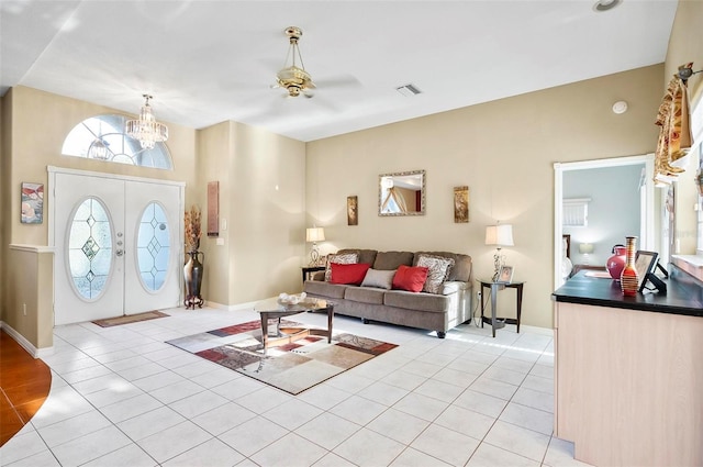 living room featuring light tile patterned floors and ceiling fan with notable chandelier