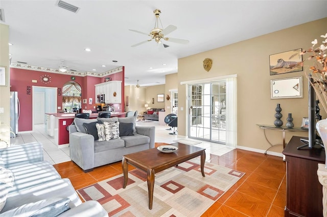 tiled living room with plenty of natural light and ceiling fan