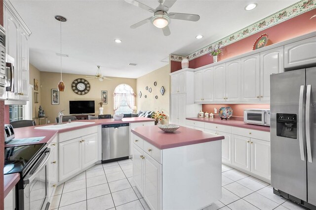 kitchen featuring appliances with stainless steel finishes, white cabinetry, a kitchen island, and pendant lighting