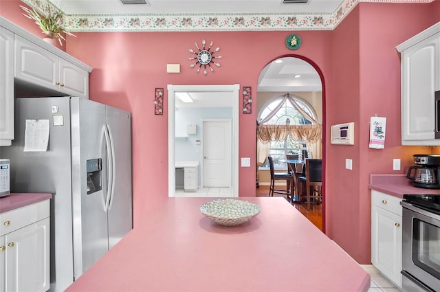 kitchen with white cabinetry, light tile patterned floors, and appliances with stainless steel finishes