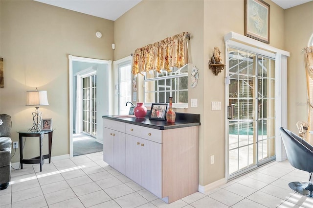 kitchen with light tile patterned floors, light brown cabinetry, and sink