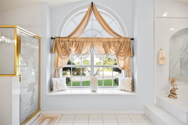 bathroom with tile patterned flooring, a shower with door, and vaulted ceiling