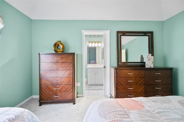 carpeted bedroom featuring sink and ensuite bath