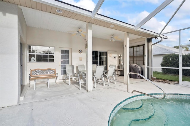 view of pool with ceiling fan, a patio area, and glass enclosure