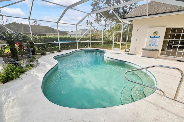 view of swimming pool with a patio area and a lanai