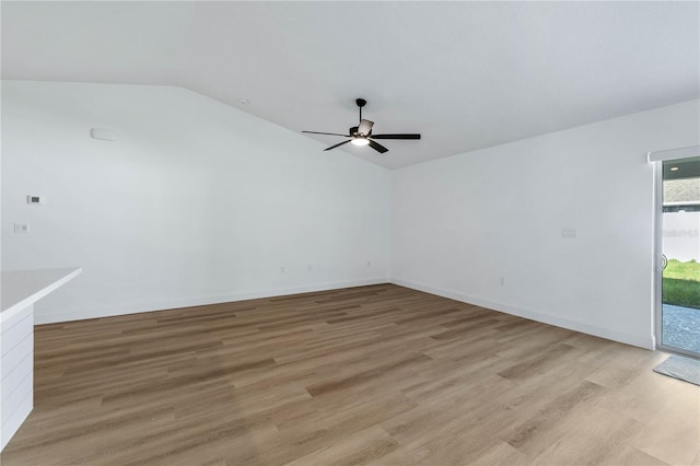 spare room featuring ceiling fan, lofted ceiling, and light hardwood / wood-style flooring