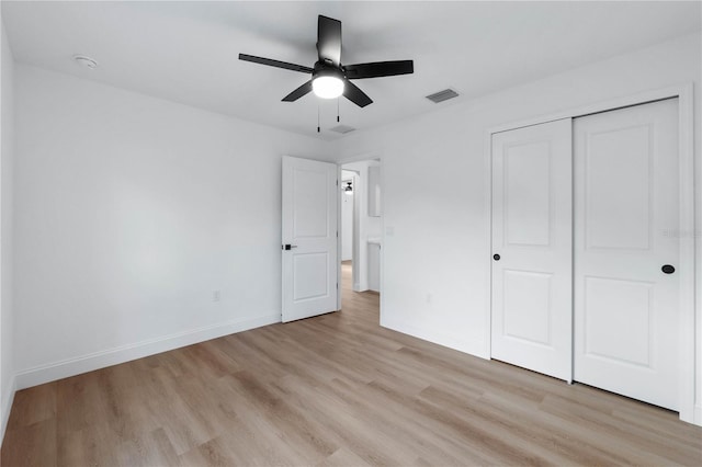 unfurnished bedroom with ceiling fan, a closet, and light wood-type flooring