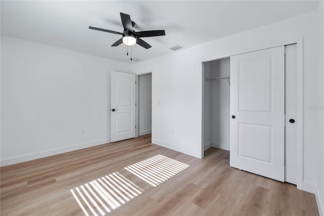 unfurnished bedroom with ceiling fan, light hardwood / wood-style flooring, and a closet