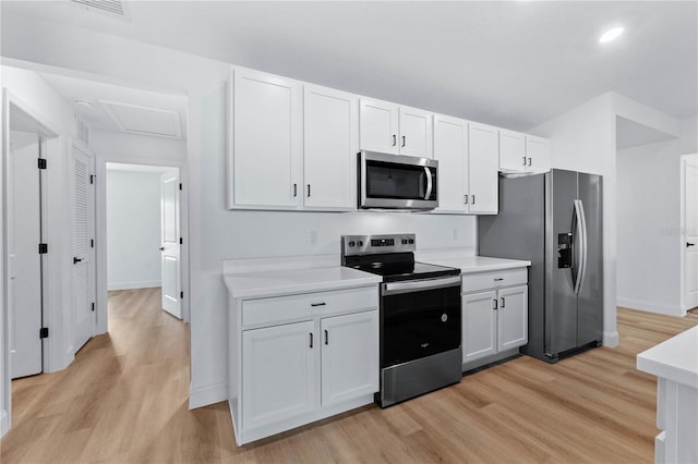 kitchen featuring white cabinets, stainless steel appliances, and light hardwood / wood-style floors