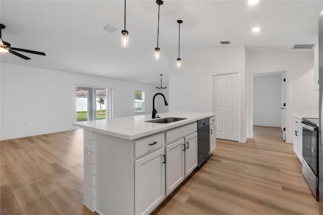 kitchen featuring sink, an island with sink, vaulted ceiling, and light wood-type flooring