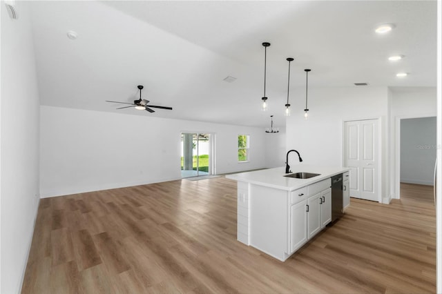 kitchen with sink, light hardwood / wood-style flooring, vaulted ceiling, a kitchen island with sink, and white cabinets