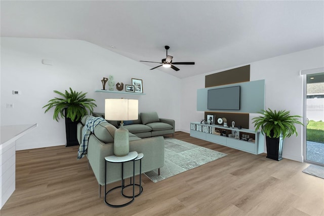 living room featuring ceiling fan, vaulted ceiling, and light hardwood / wood-style flooring