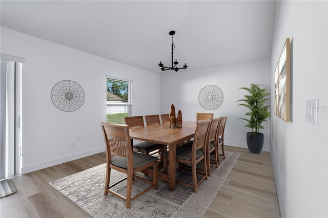 dining area featuring light hardwood / wood-style floors and a notable chandelier