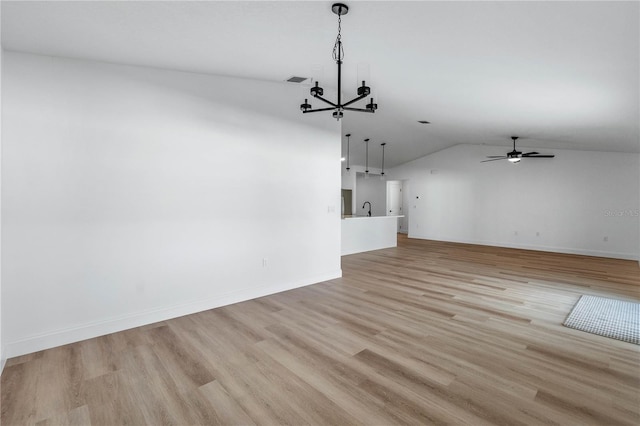 unfurnished living room with ceiling fan with notable chandelier, light hardwood / wood-style floors, vaulted ceiling, and sink