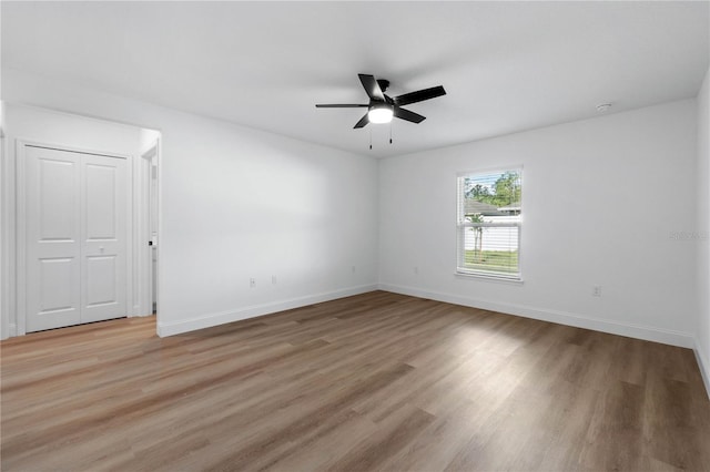 empty room with hardwood / wood-style floors and ceiling fan