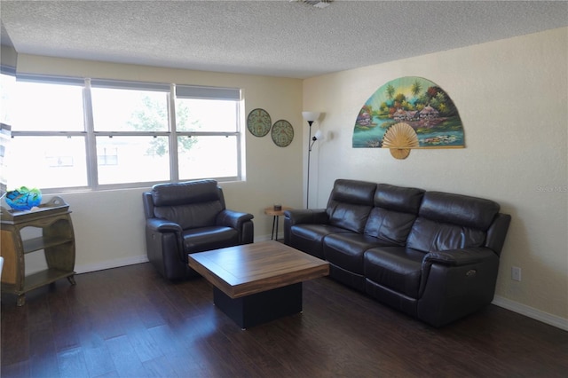 living room featuring dark wood-type flooring and a textured ceiling