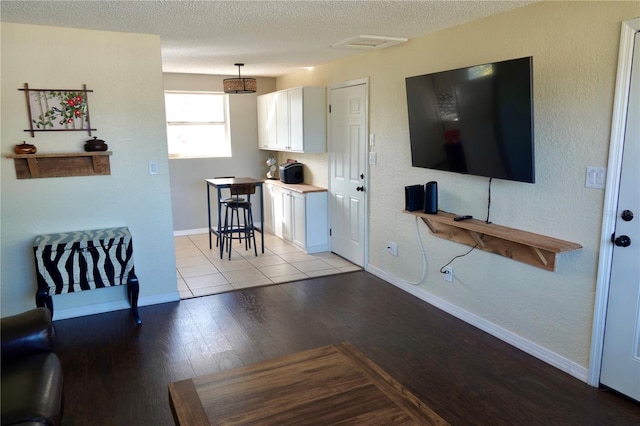 living room with light hardwood / wood-style floors and a textured ceiling