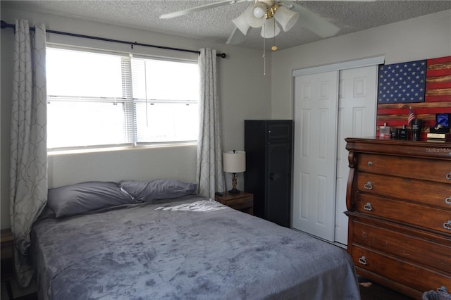 bedroom featuring ceiling fan, a closet, and a textured ceiling