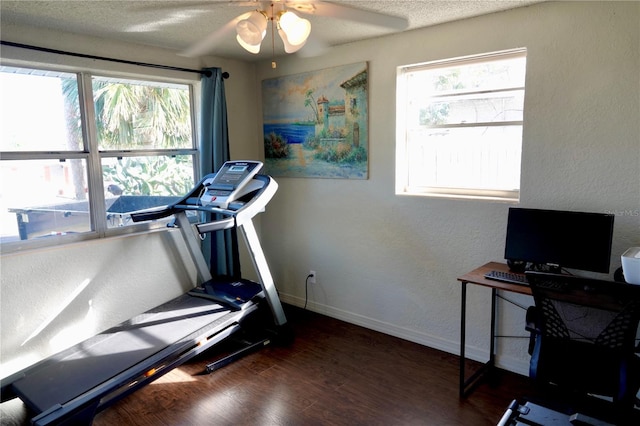 workout room featuring plenty of natural light, dark hardwood / wood-style floors, a textured ceiling, and ceiling fan