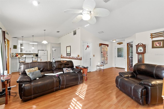 living room with vaulted ceiling, light hardwood / wood-style flooring, and ceiling fan