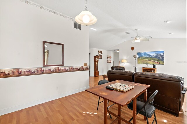 dining area featuring ceiling fan, lofted ceiling, and light wood-type flooring