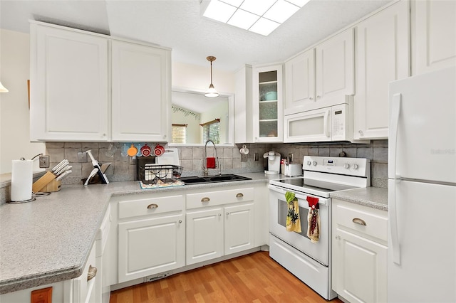 kitchen featuring light hardwood / wood-style flooring, white cabinets, pendant lighting, and white appliances