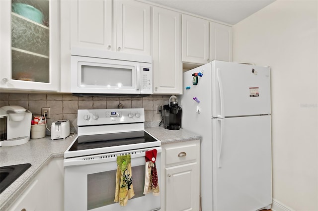 kitchen featuring decorative backsplash, white cabinetry, and white appliances