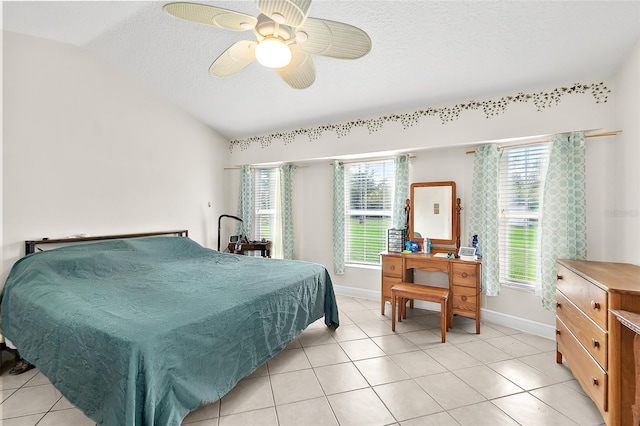 tiled bedroom featuring ceiling fan, a textured ceiling, and vaulted ceiling