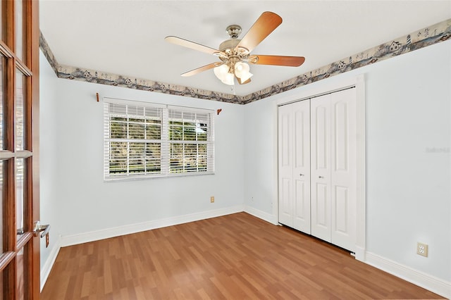 unfurnished bedroom featuring hardwood / wood-style flooring, ceiling fan, and a closet