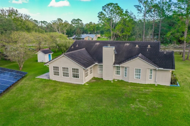 back of property featuring a yard and a shed