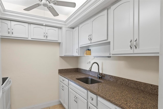 kitchen with white cabinets, ornamental molding, and sink