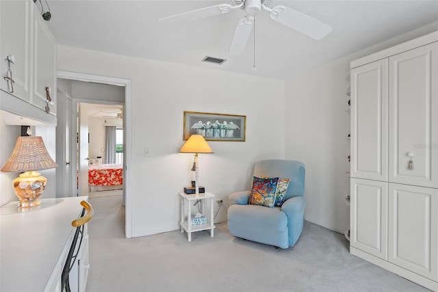 living area featuring ceiling fan and light carpet