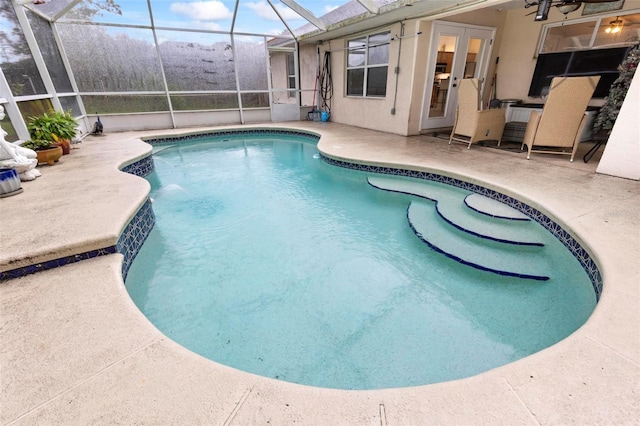 view of swimming pool featuring a patio and glass enclosure