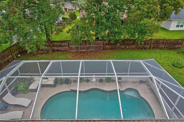 view of swimming pool featuring glass enclosure and a lawn