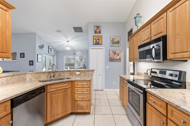 kitchen featuring appliances with stainless steel finishes, lofted ceiling, sink, light tile patterned floors, and light stone counters